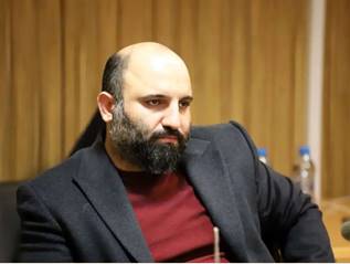 A person in a suit

AI-generated content may be incorrect.